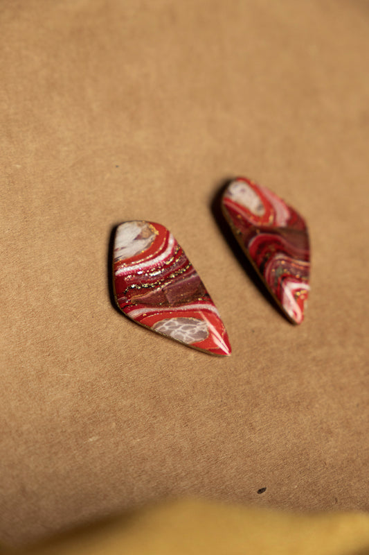 rode oorstekers met marmereffect en faux steen look met gouden accenten, gemaakt van polymeerklei en voorzien van roestvrijstalen oorstekers